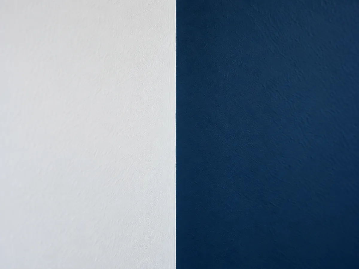 Witte muur naast een donkerblauw geschilderde muur met een strakke rand